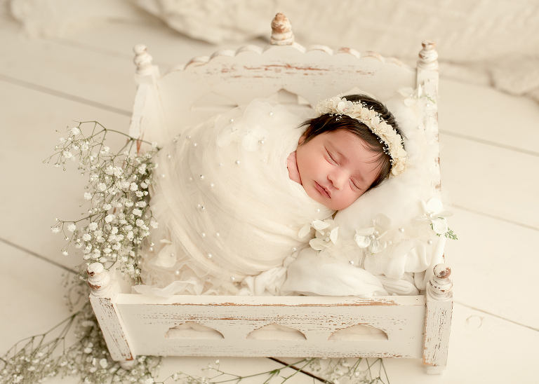 Newborn baby girl wrapped in soft cream blanket during photoshoot by Allen newborn photographer in Frisco studio