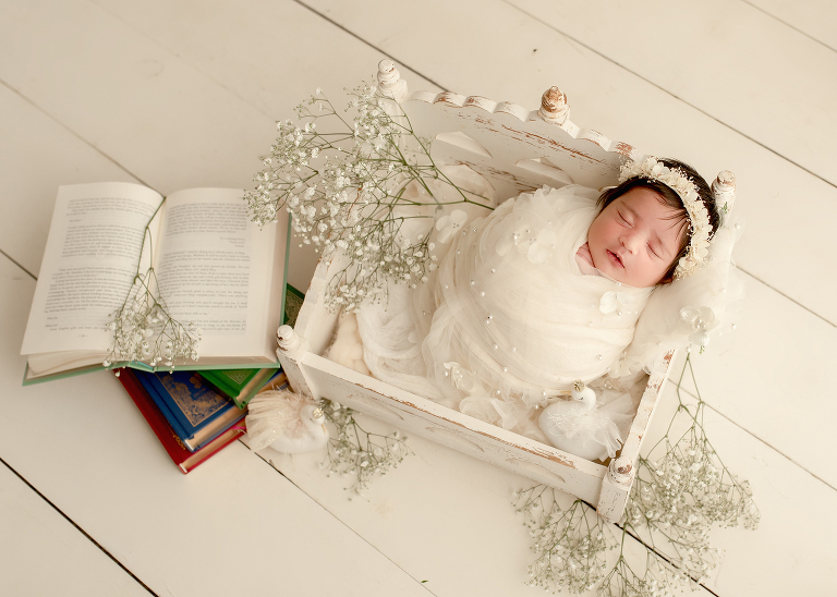 Newborn baby girl wrapped in soft cream blanket during photoshoot by Allen newborn photographer in Frisco studio