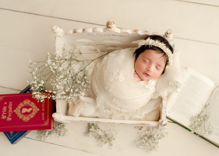 Newborn baby girl wrapped in soft cream blanket during photoshoot by Allen newborn photographer in Frisco studio