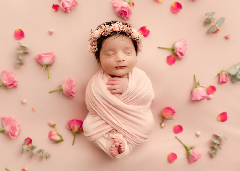 Professional newborn photographer in Allen TX capturing cute floral pink portraits of baby girl