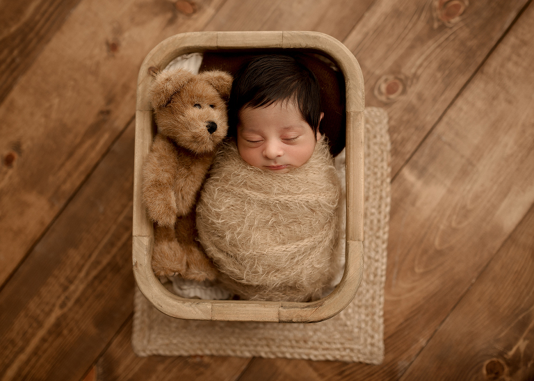 Professional Plano newborn photographer capturing baby boy portraits in blue, white, and brown tones