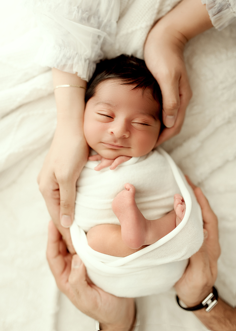 Professional Plano newborn photographer capturing baby boy portraits in blue, white, and brown tones