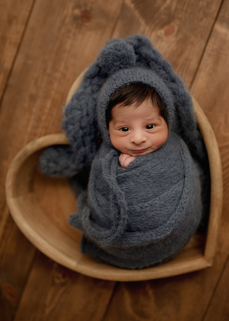 Professional Plano newborn photographer capturing baby boy portraits in blue, white, and brown tones